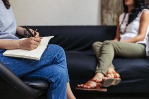 two people on couch talking about finding addiction treatment therapy