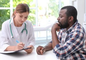 female doctor counseling man about prescription drug addiction treatment