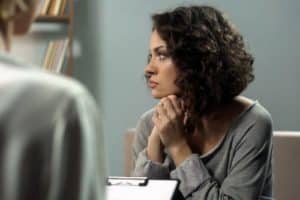 women seated and staring into the distance considering a depression treatment program