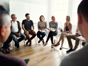 group of men and women experiencing the 3 benefits of group therapy during a session