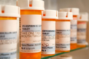 several bottles of prescription medication sit easily accessible in a medicine cabinet