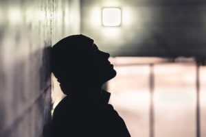 Person contemplating the link between trauma and substance abuse