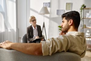 Patient sitting on couch, talking about his cocaine use disorder with professional