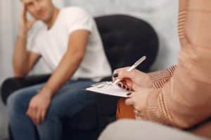 Health professional writing notes on patient with marijuana use disorder