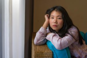Woman sitting on couch, pondering if Adderall is addictive