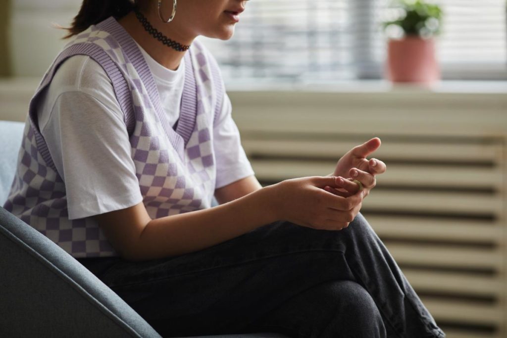 Young person sitting down, pondering individual therapy