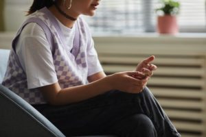 Young person sitting down, pondering individual therapy