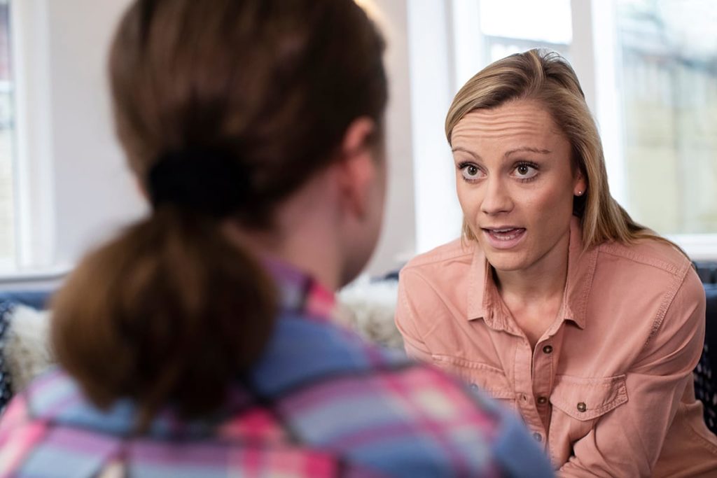 young woman asking addiction treatment professional what are the benefits of a vivitrol treatment program