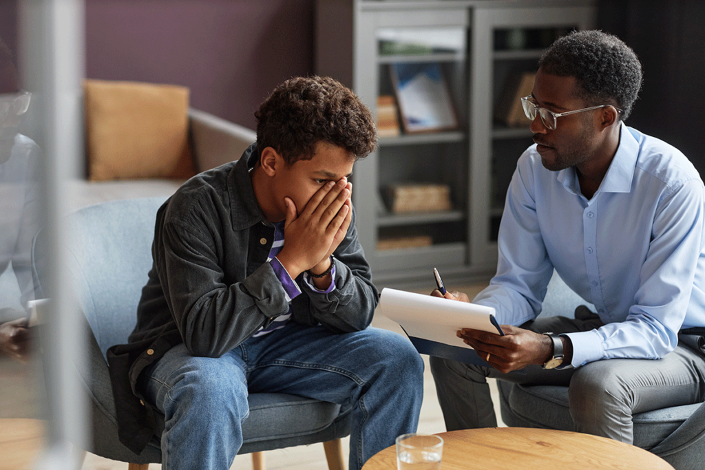 concerned young man talking to behavioral health specialist asking what are the best ways to treat anxiety