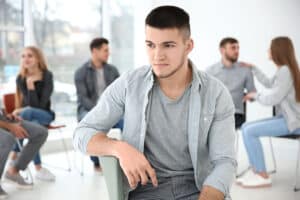 young man participating in painkiller addiction treatment program as part of his path toward recovery