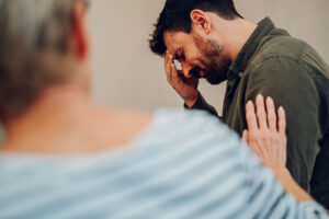 a person comforts another in a PTSD treatment program