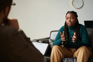 therapist discusses co-occurring disorders treatment with serious young woman in an office setting.