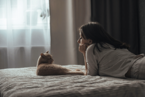 woman relaxing on her bed enjoying the company of her cat as one of the tips on overcoming seasonal depression